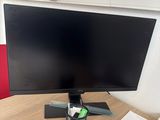 a computer monitor sitting on top of a wooden table