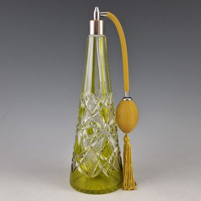 une image représentant un flacon de parfum en verre vert muni d'un bouchon doré