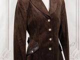 brown sued jacket on a mannequin stand in front of a white wall