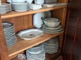 beaucoup d'assiettes et de casseroles sur les étagères de la cuisine