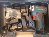a cordless drill in a plastic case with other tools in it