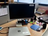 un ordinateur portable posé sur un bureau, devant un écran