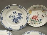 four plates with blue and white floral designs on them on a table