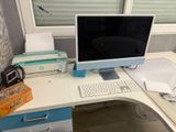 a desk with a computer monitor and printer on it