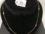 a close up of a black hat with a gold necklace on it