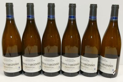 six bouteilles de vin sont alignées sur une table