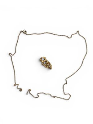 a gold necklace with a chain that has a small piece of jewelry on it