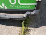 a green electric vehicle parked on the side of the road
