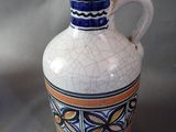 a white vase with a blue and orange design on it