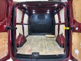 a red van with a wooden floor in the back of it