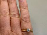 a woman ' s hand with a diamond ring on it