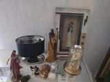 quelques figurines sont posées sur une table en verre sur laquelle se trouve une lampe