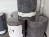 Des bougies sont empilées sur une étagère dans un magasin ; elles sont munies d'étiquettes.