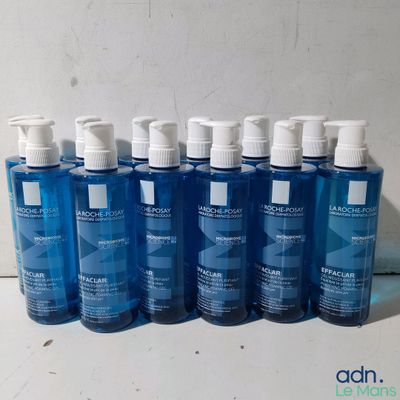 plusieurs bouteilles contenant un liquide bleu posées sur une table blanche