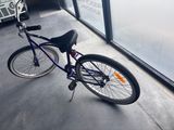 a purple bicycle parked in front of a building