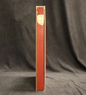 un livre rouge posé sur une table recouverte d'un tissu noir