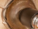 a close up of a metal pipe on a wooden floor