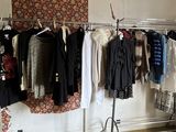 many clothes hanging on a rack in a room
