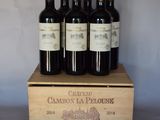 quatre bouteilles de vin rouge dans un coffret en bois posé sur une table