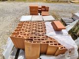 un tas de briques posé par terre à côté d'un autre tas de briques