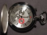 un gros plan d'une montre de poche en argent posée sur une table