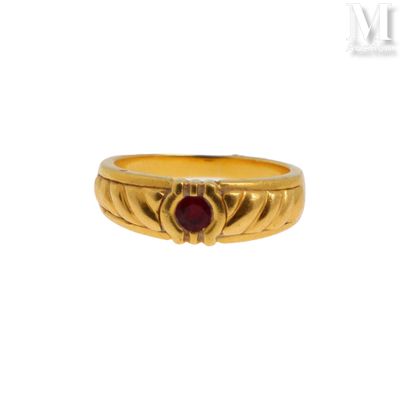 gros plan d'une bague en or avec une pierre en rubis