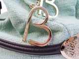 a necklace that has a letter b on it