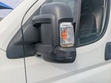 a white van with a black side view mirror and a cell phone in the side view mirror