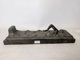 sculpture en bronze représentant une femme assise sur un rocher, de dos par rapport à l'appareil photo