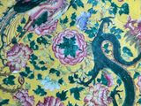 a yellow plate with a dragon and flowers on it