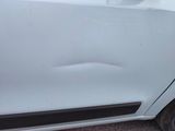 a car that has been dented and is parked on the side of the road