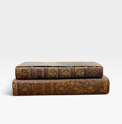 deux vieux livres empilés l'un sur l'autre sur une surface blanche