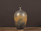 a vase that is sitting on a table in front of a wall