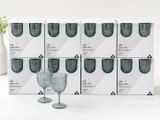 plusieurs verres à vin vides posés sur une table, à côté d'un vase