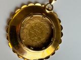 an image of a gold pendant with a coin in the center