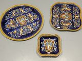 trois assiettes décorées de bleu et d'or posées sur une table