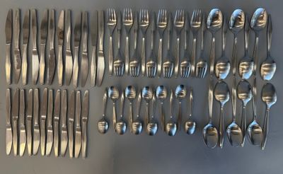 de nombreuses fourchettes et cuillères disposées sur la table
