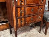 une commode, avec une chaise et une table en arrière-plan