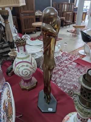 une statue représentant une femme tenant une balle posée sur une table