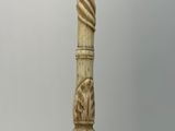 a very long wooden stick with a spiral design on it