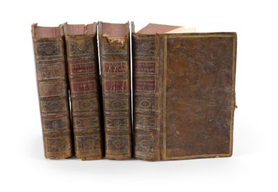 trois vieux livres posés l'un sur l'autre sur une surface blanche