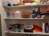 une petite salle de bains avec beaucoup d'objets sur les étagères