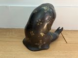 a small statue of a person sitting on a wooden floor