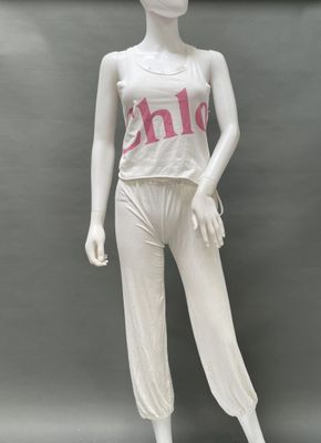 female mannequin wearing a white top and white pants with pink letters