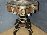 une petite table avec un plateau en marbre, placée dans un coin