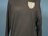 the sweater is black and has a flower design on it