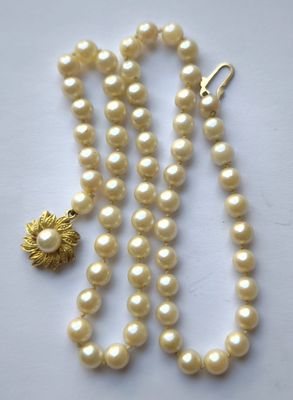 gros plan d'un collier de perles sur une surface blanche
