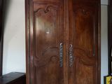 une grande armoire en bois dans le coin d'une pièce