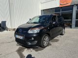 la petite voiture noire est garée devant un bâtiment