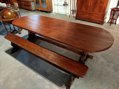 une table en bois avec deux bancs au milieu de la pièce